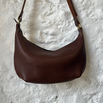 Handcrafted small cross body bag in textured brown coloured leather. Made from vegetable tanned leather with adjustable strap and zip fastening.