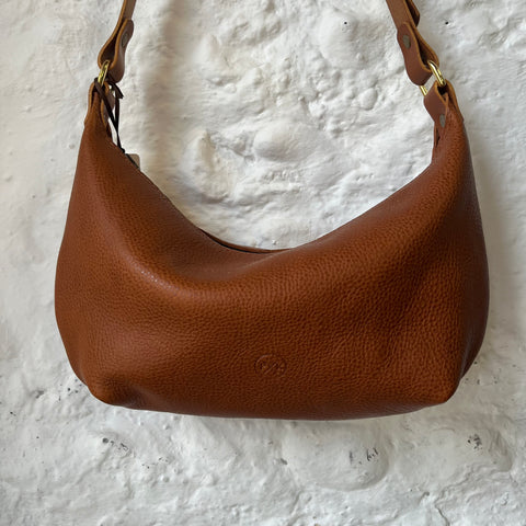 Handcrafted small cross body bag in tan coloured leather. Made from vegetable tanned leather with adjustable strap and zip fastening.