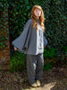 Woman wearing  grey shaped leg cotton and linen  trousers. Raw hem details and side pockets.