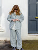 Model wearing pale grey spring trousers crafted using cotton and linen blend fabric. Elastic waistband and seam details.