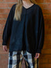 Woman wearing black fine cotton voile oversized top. Loose and floaty with raw hem details.