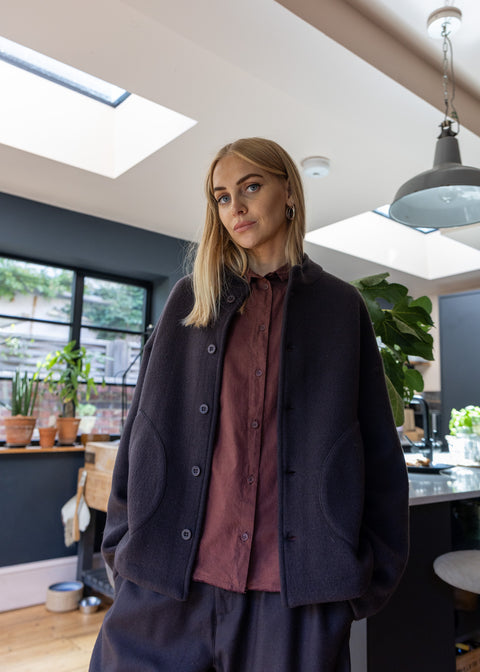 Woman wearing a dark brown jacket over cotton shirt