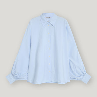 Woman wearing pale blue colour  cotton loose fitting shirt with balloon shaped sleeves. Featuring collar, button through front and cuffs.
