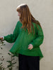 Woman wearing green fine cotton voile oversized top. Loose and floaty with raw hem details.